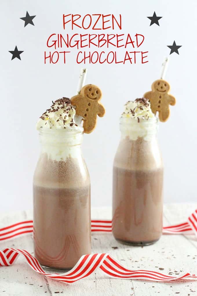 Frozen gingerbread hot chocolate in two small glass milk bottles, topped with whipped cream and chocolate shavings with a straw and a small gingerbread man in each.