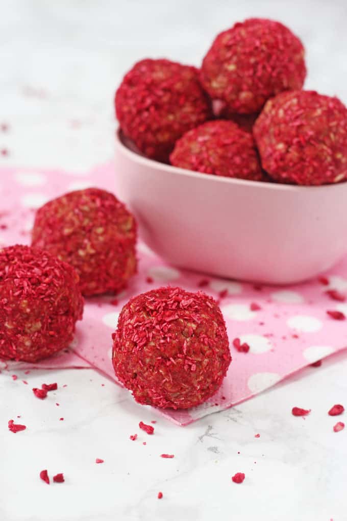 Raspberry & Coconut Energy Bites piled into a small pink melamine bowl.