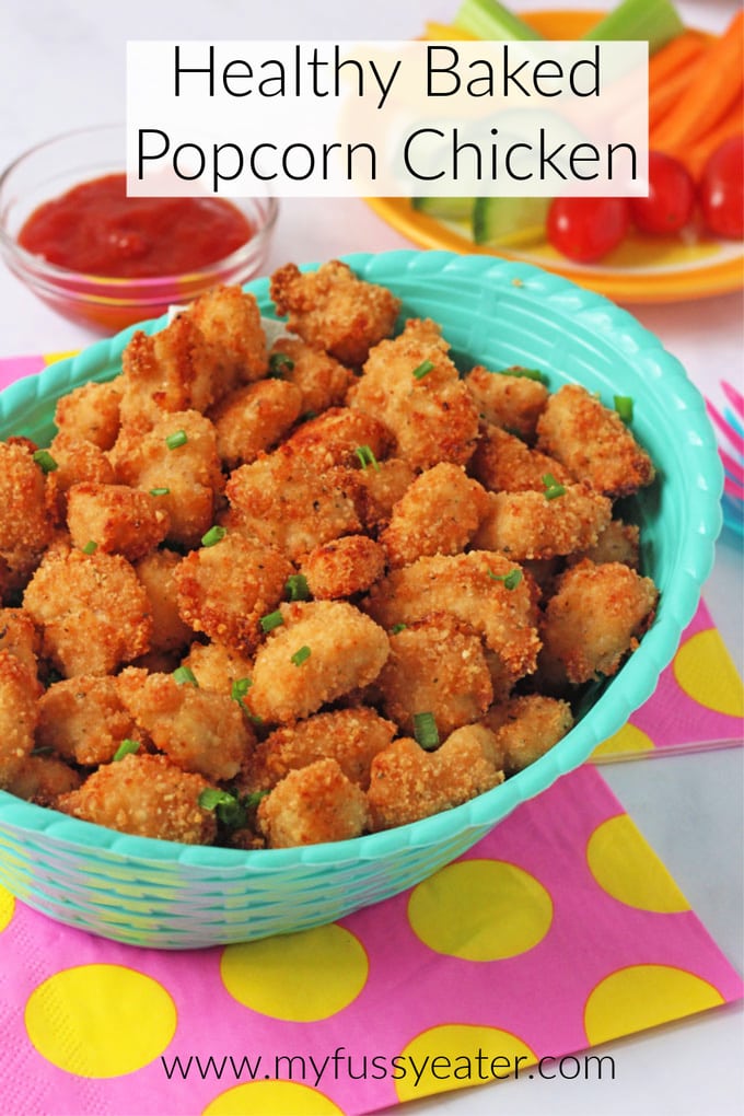 Healthy baked popcorn chicken, served in a turquoise food basket, with a small dipping bowl of tomato ketchup.