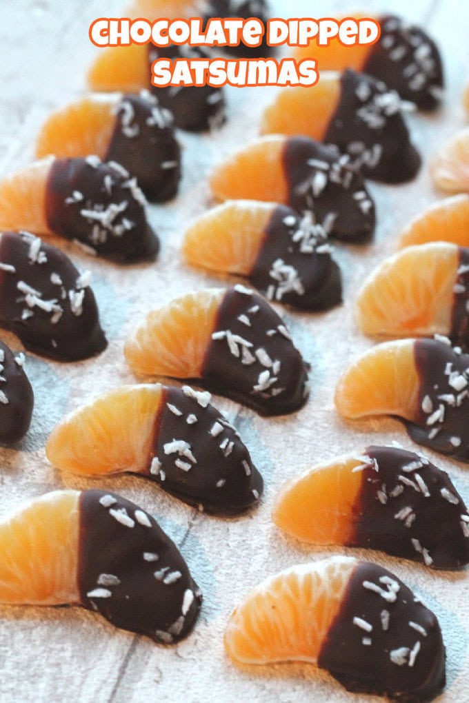 Chocolate Dipped Satsumas arranged  in lines on a white wooden surface.